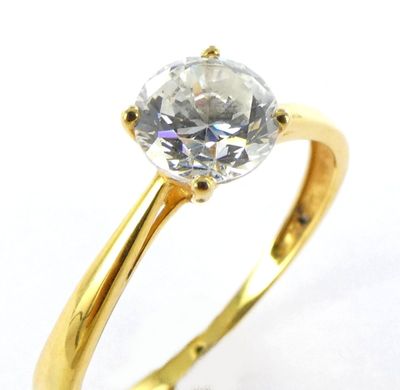 a close up of a diamond ring on a white surface