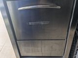 stainless steel dishwasher sitting on top of a counter in a kitchen