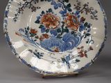 two plates and a bowl with flowers on them on a table