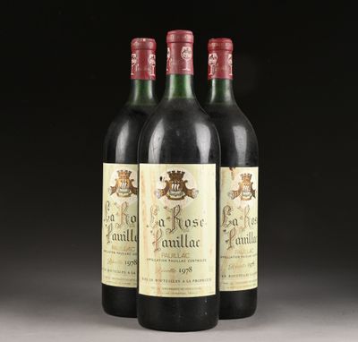 Trois bouteilles de vin sont posées sur une table devant un fond noir.