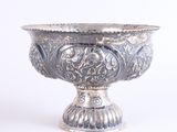 a silver bowl that is sitting on a white surface
