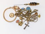 un tas de bijoux en or et en argent posés sur une surface blanche