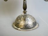 a silver plate with a bell on top of it