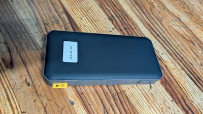 une photo d'un téléphone portable noir posé sur une table en bois