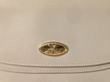 the back of a white purse with a gold buckle on it