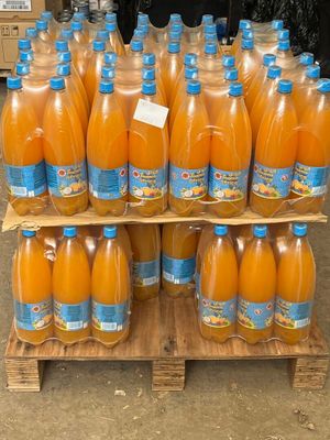 de nombreuses bouteilles de jus d'orange posées sur une palette