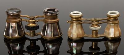 trois jumelles en laiton ancien posées sur une surface noire