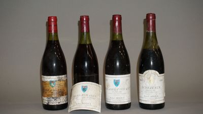 quatre bouteilles de vin sont alignées sur une table