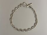 a silver bracelet with a heart charm on it