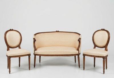 three chairs and a couch in a room with a white wall