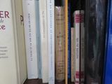 de nombreux livres qui se trouvent sur une étagère dans la pièce