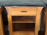 two wooden cabinets with black tops and a black counter top