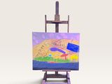 un petit chevalet sur lequel est posé un tableau, posé sur une surface blanche