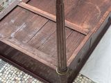 a bed with a wooden frame sitting on a sidewalk
