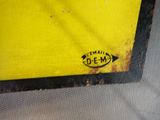 a close up of a yellow and black sign on a wall