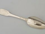 silver spoon on a white surface with a silver spoon in the middle of it