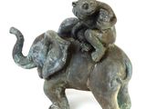 a statue of a man riding an elephant with a cat on its back
