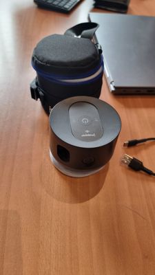 une table sur laquelle se trouvent un ordinateur portable, un casque et une enceinte