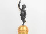 une image représentant la statue d'un homme tenant une bougie posée sur une table