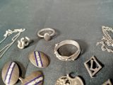 many different types of silver jewelry on a table