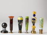 five different vases that are lined up on a white surface