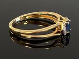 an image of a gold ring with a blue sapphire and a diamond