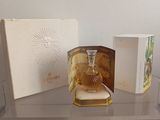 a glass shelf with a bottle of perfume and a box on it
