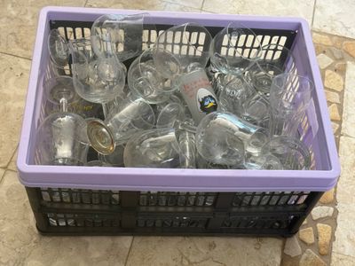 a purple box filled with empty wine glasses on a tiled floor