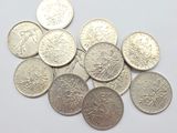 some coins are sitting on a white surface with a white background