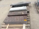 many pieces of granite on pallets in a warehouse