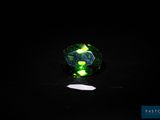 a close up of a green and black ring on a black surface