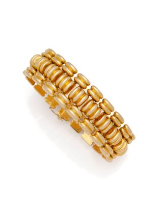 une bague en or jaune ornée de rangées de perles sur fond blanc