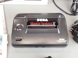 a nintendo game system sitting on a table with a charger