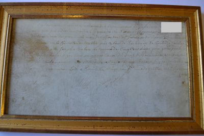 an old document is hanging on a wall next to a blue wall