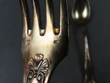 a silver fork and a silver spoon on a table