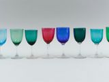 several different colored wine glasses are lined up in a row