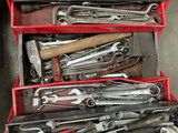 de nombreux outils dans une boîte à outils rouge posée par terre