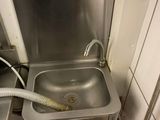 un lavabo muni d'un tuyau d'arrosage dans une salle de bains