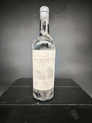 une vieille bouteille de vin posée sur une table noire
