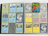 de nombreuses cartes Pokémon rangées dans un classeur posé sur la table