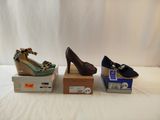 three pairs of women ' s shoes sitting on top of boxes on a white surface