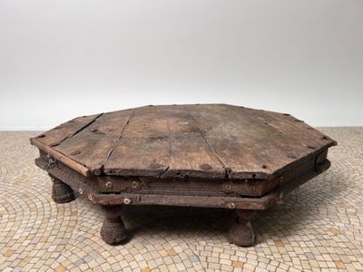 an old wooden coffee table with a stone top on a tiled floor