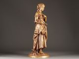 bronze statue of a woman holding a basket of flowers on a pedestal