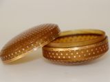 pair of gold - plated boxes with stars on them sitting on a white surface