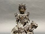 a silver statue of a woman sitting on top of a table