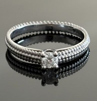 a close up of a diamond ring on a black surface