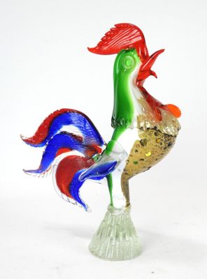 un coq en verre posé sur un socle en verre