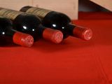 several bottles of wine are lined up on a red table cloth