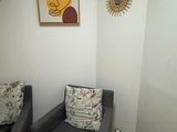 deux chaises dans un coin d'une pièce où est accroché un tableau au mur