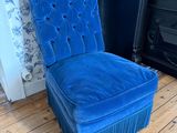 une image représentant une chaise bleue posée sur un parquet